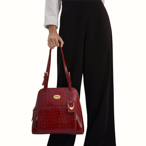 Woman holding Hidesign Marsala crocodile-textured leather tote bag with a structured shape & straps.