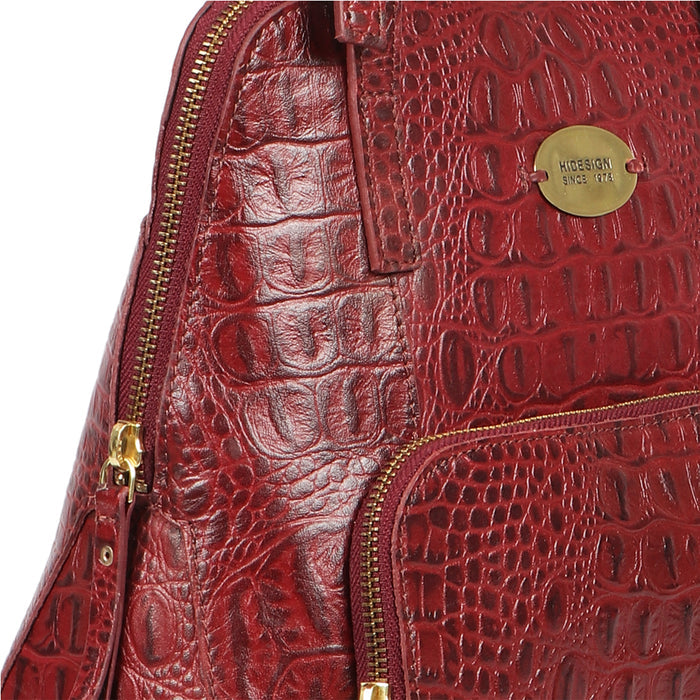 Close-up of a red crocodile-texture leather Hidesign tote bag with gold zippers & logo plate detail.