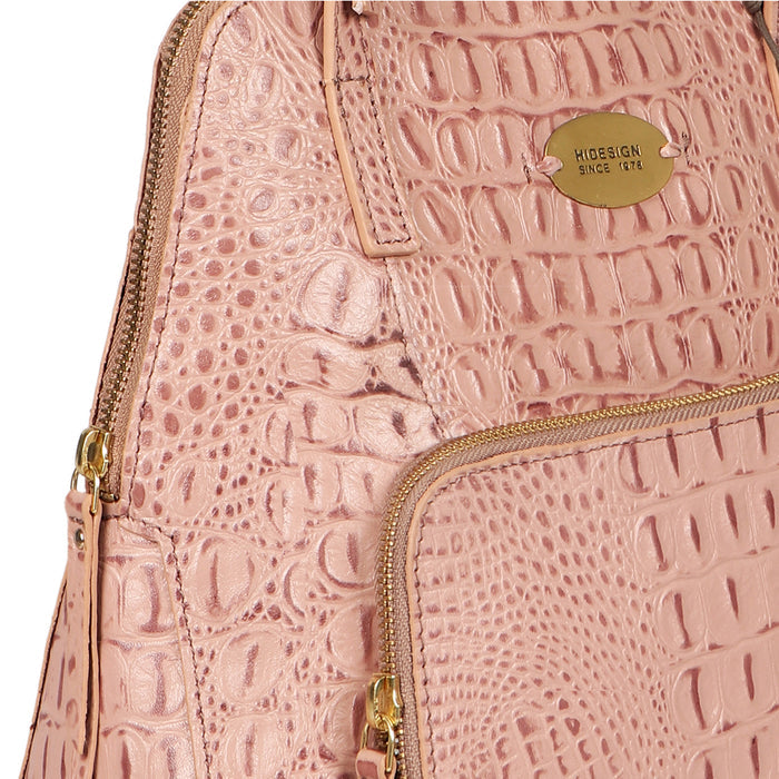 Close-up of Hidesign's pink crocodile-texture leather tote bag with gold logo plaque and zip detail.