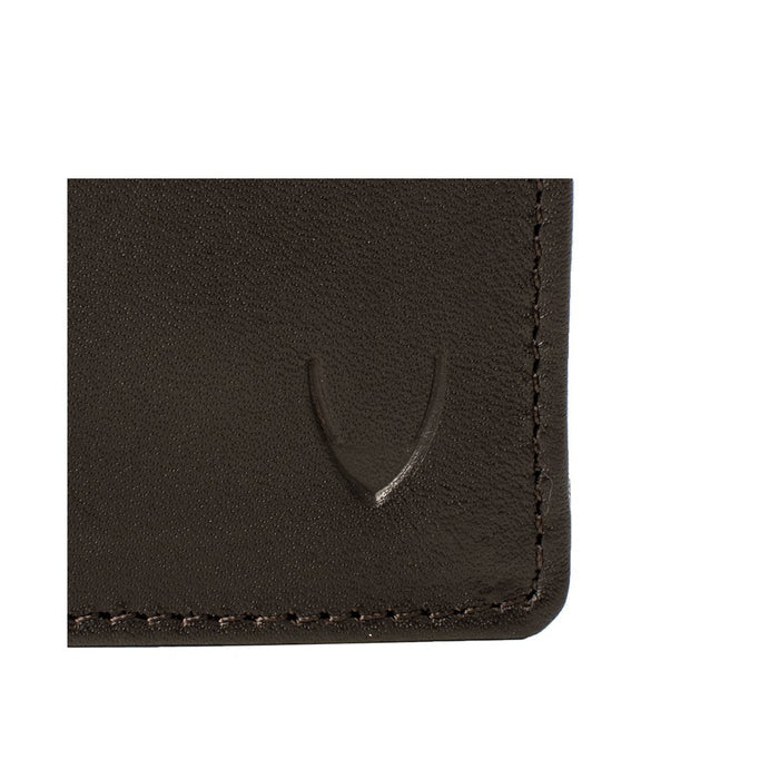 Close-up of dark brown leather wallet corner showing embossed mark and neat stitched detailing trim.