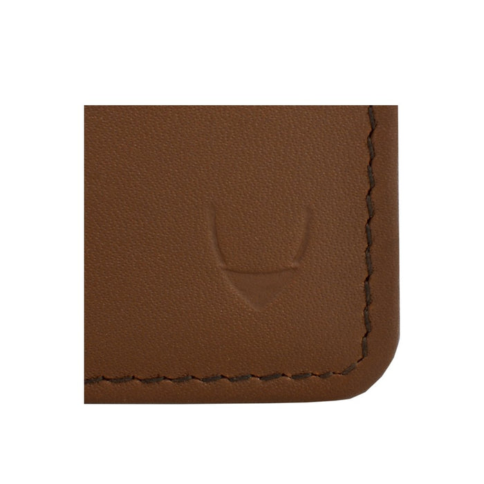 Embossed logo detail on tan leather wallet corner, showcasing fine-grain texture and neat stitching.