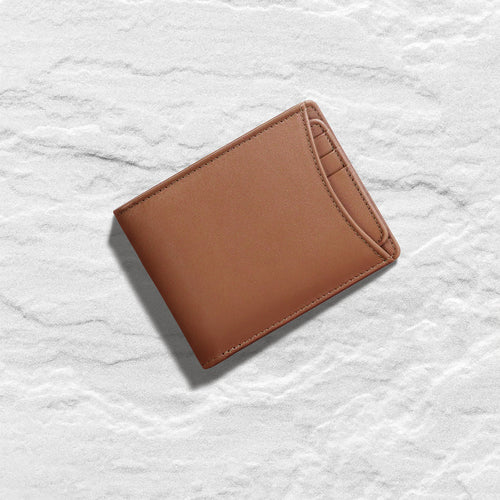 Resting an Rf tan leather bifold wallet for men on a marble surface with an exterior card pocket.