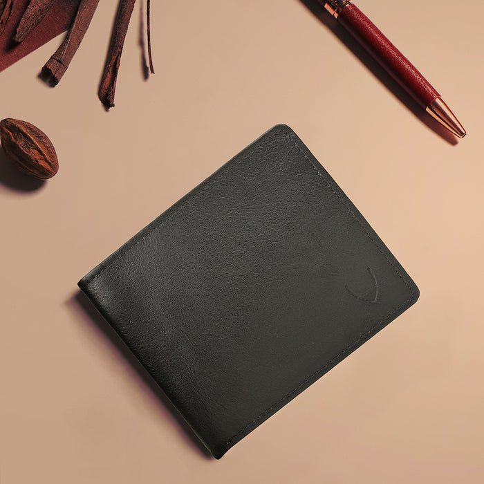 Minimalist black leather wallet styled with pen & accessories, showcasing Hidesign's premium crafts.