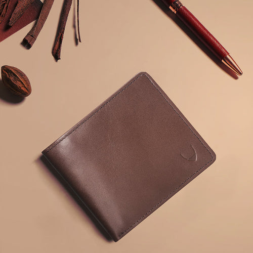Tan leather bi-fold wallet styled with pen and accessories, featuring embossed Hidesign logo detail.