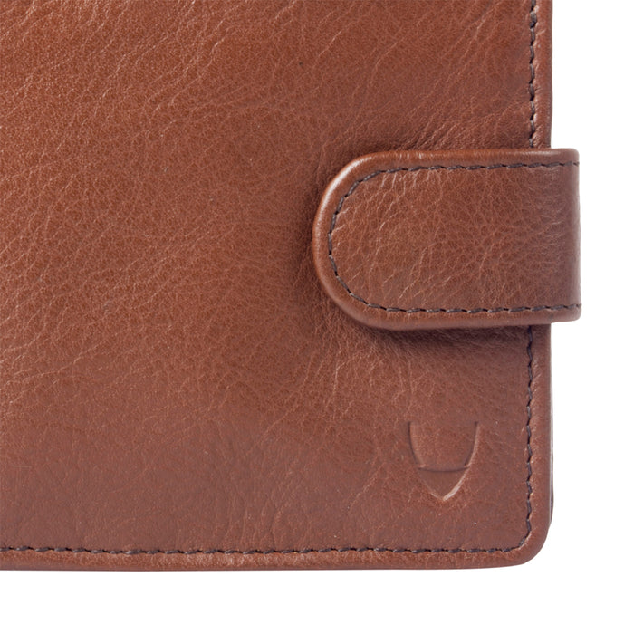 Close-up of a brown leather Hidesign wallet showing textured surface, stitched edges & a strap logo.