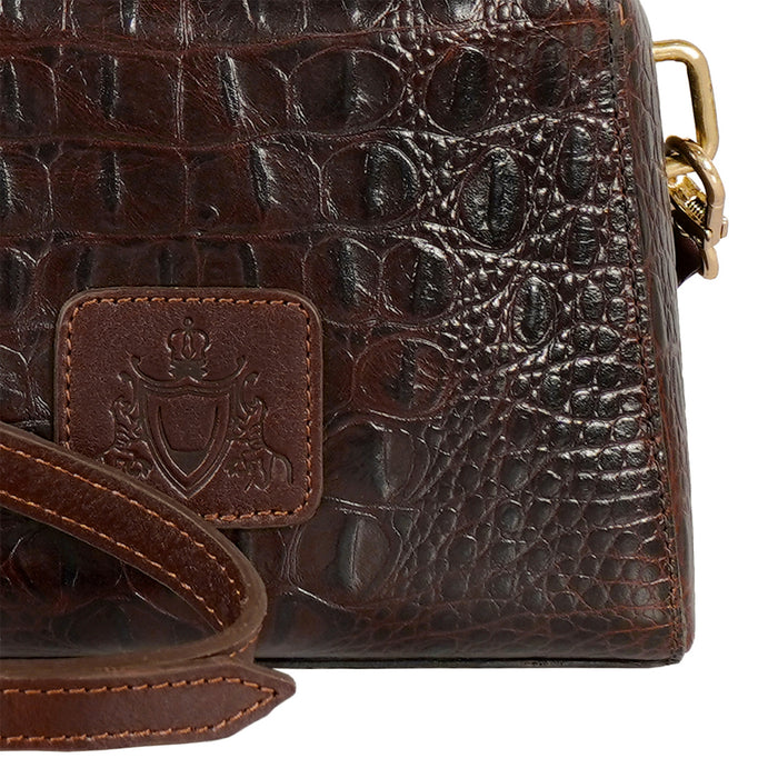 Close-up of Hidesign Ritz 01 brown leather sling bag showing textured leather & embossed logo patch.